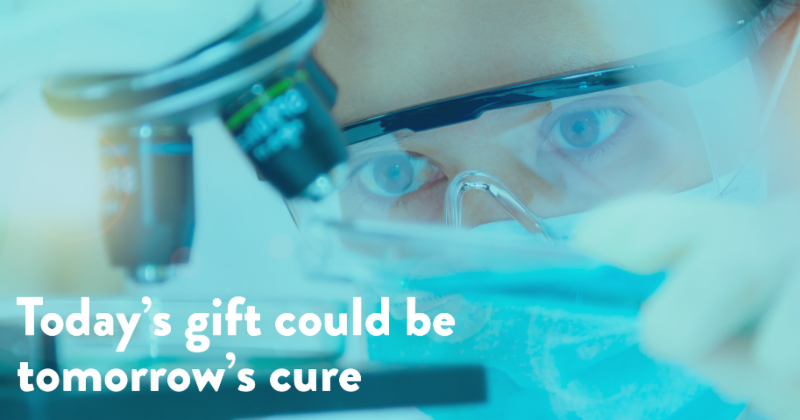 Close up on scientist wearing mask, looking into microscope, with text that reads, Today's gift could be tomorrow's cure