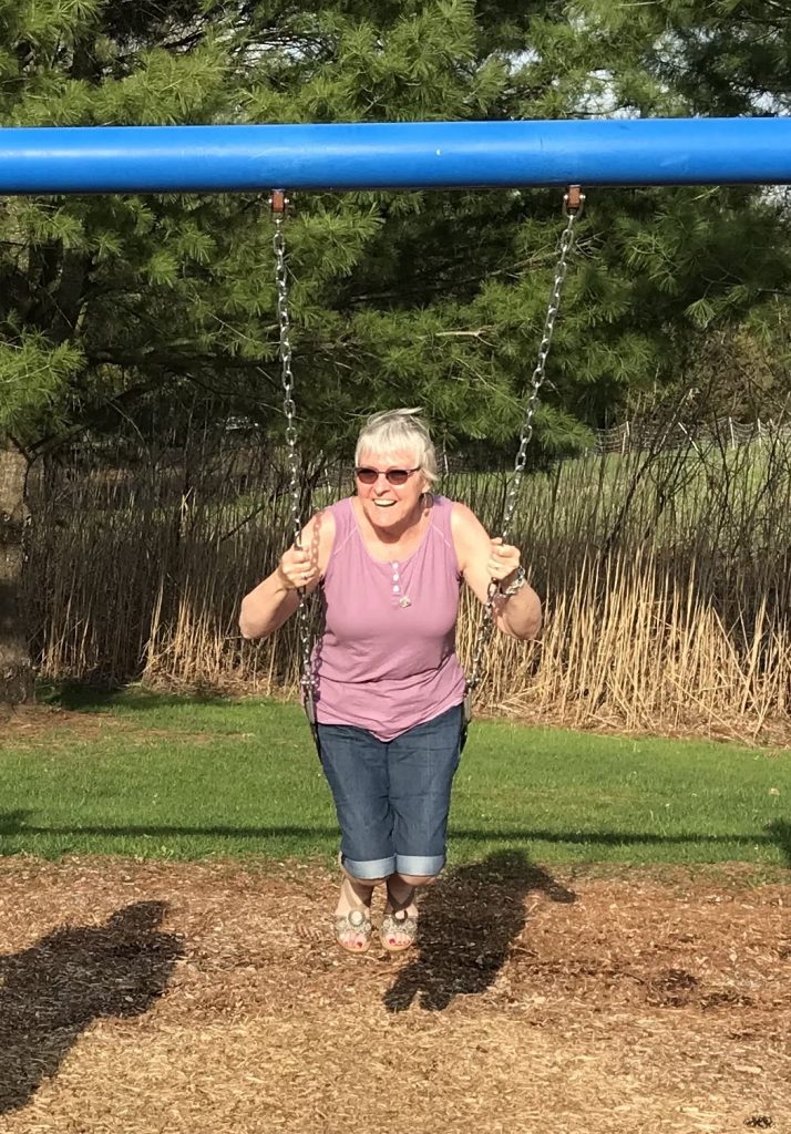 Jesse Dunn's mother smiling on swing in backyard