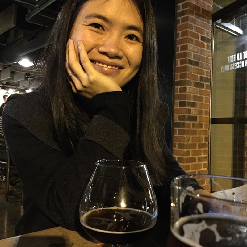 Hui Shen PhD, smiling at outdoor restaurant