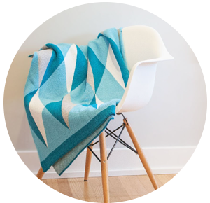Seek and Swoon teal and white throw draped over white chair