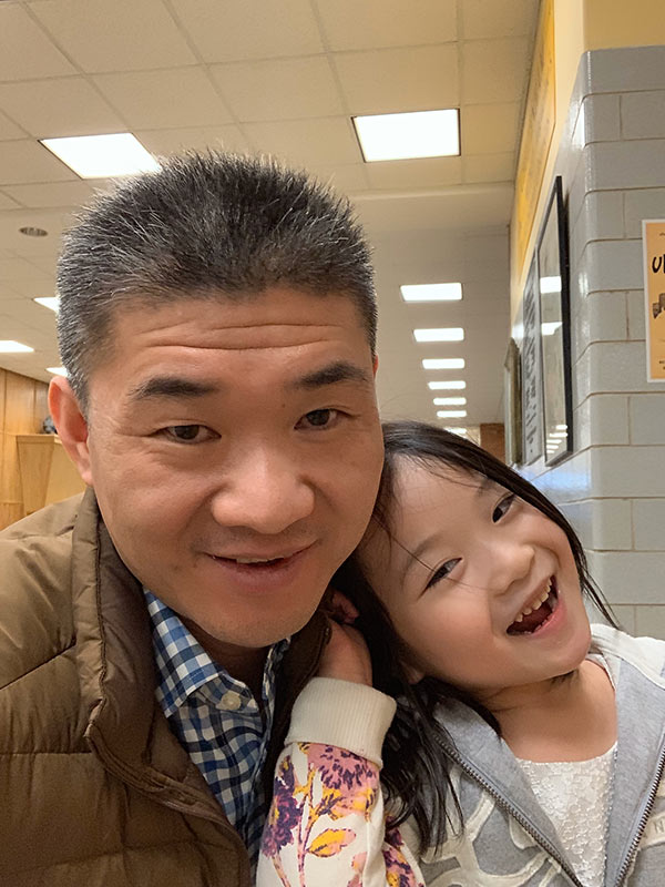 Dr. Zhang with young girl, both smiling