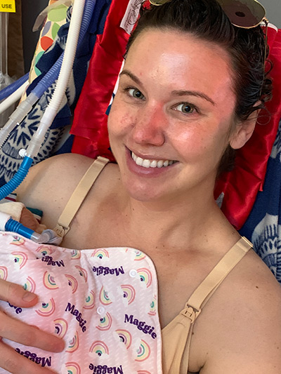 Becca Cahill smiling, holding small baby