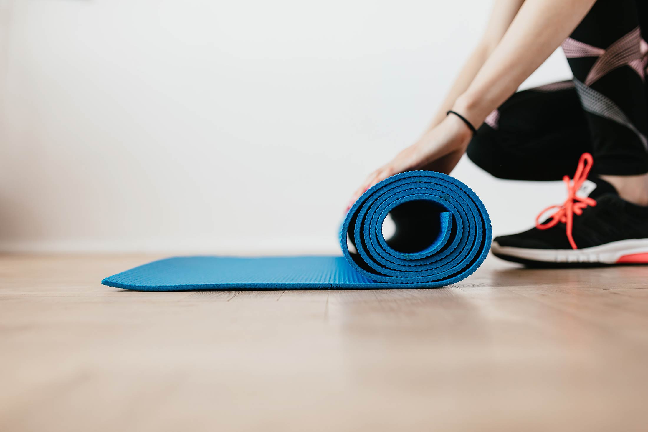 person rolling yoga mat