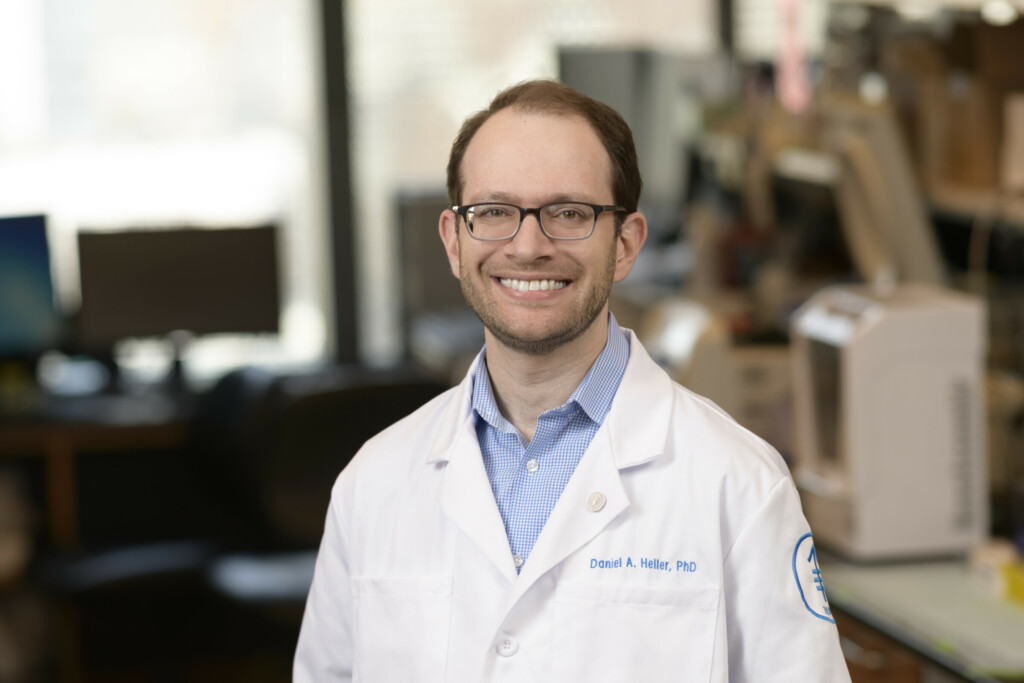 Daniel Heller in lab coat, smiling in research lab