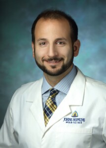 Photo: Dr. Joshua Doloff in professional headshot, wearing white lab coat