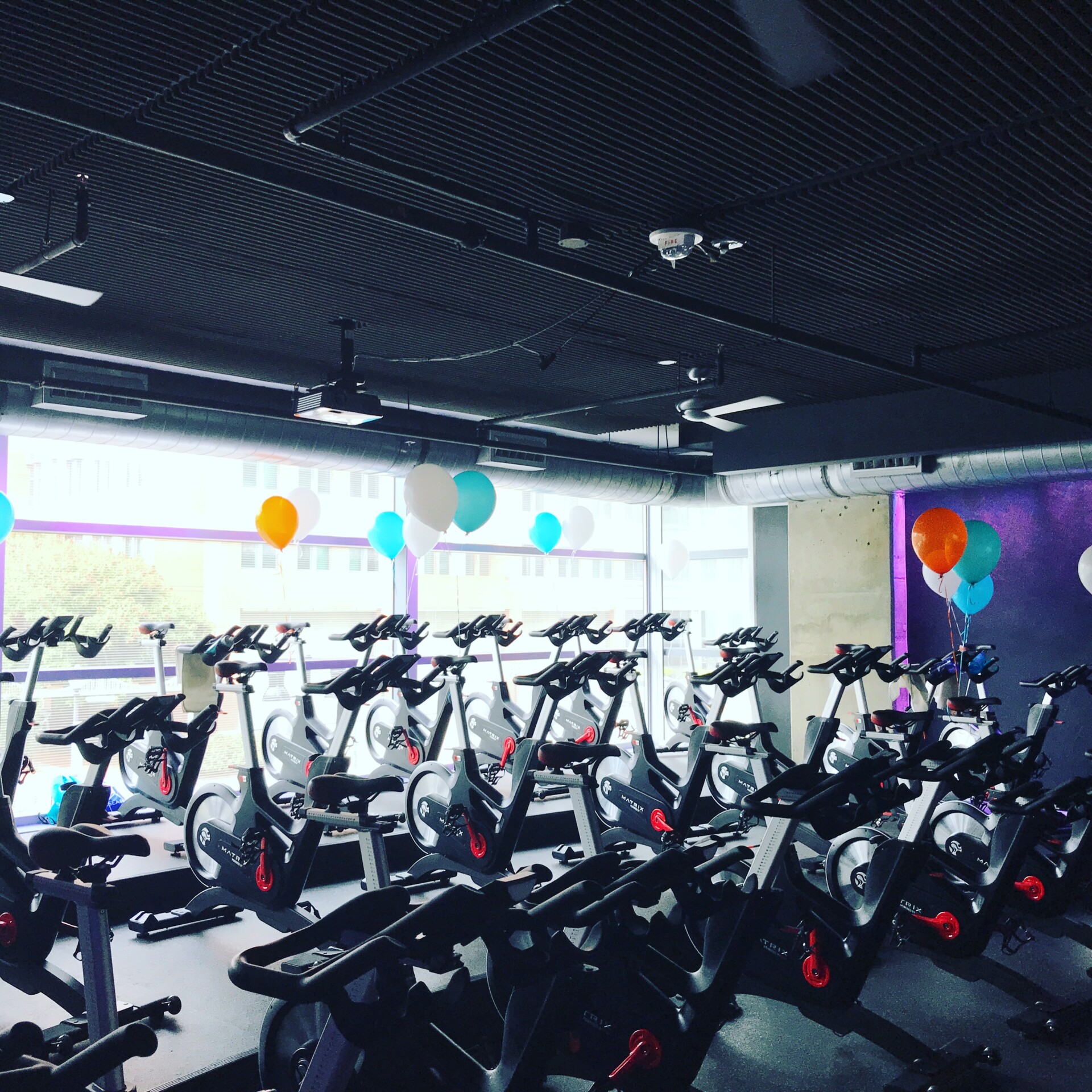 Indoor cycling studio with teal and orange balloons