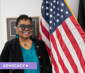 Vernelia, an ovarian cancer survivor and OCRA Advocate Leader, stands next to the American flag at OCRA's in-person Advocacy Day
