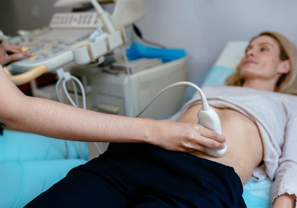 Doctor using an ultrasound and screening woman's uterus