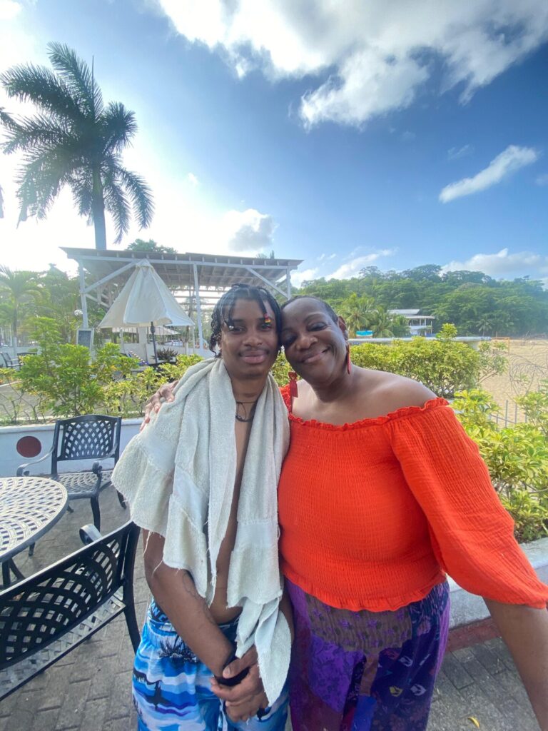 A cancer survivor and her son pose on a beach.